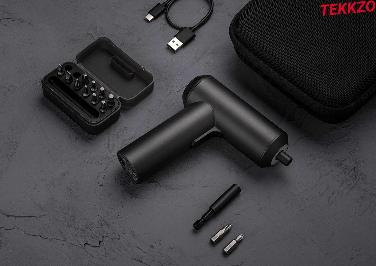 Black cordless electric screwdriver with assorted bits, charging cable, and carrying case on dark surface