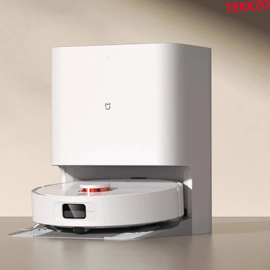 White robotic vacuum cleaner docked into a sleek automatic charging and dust collection station on beige surface