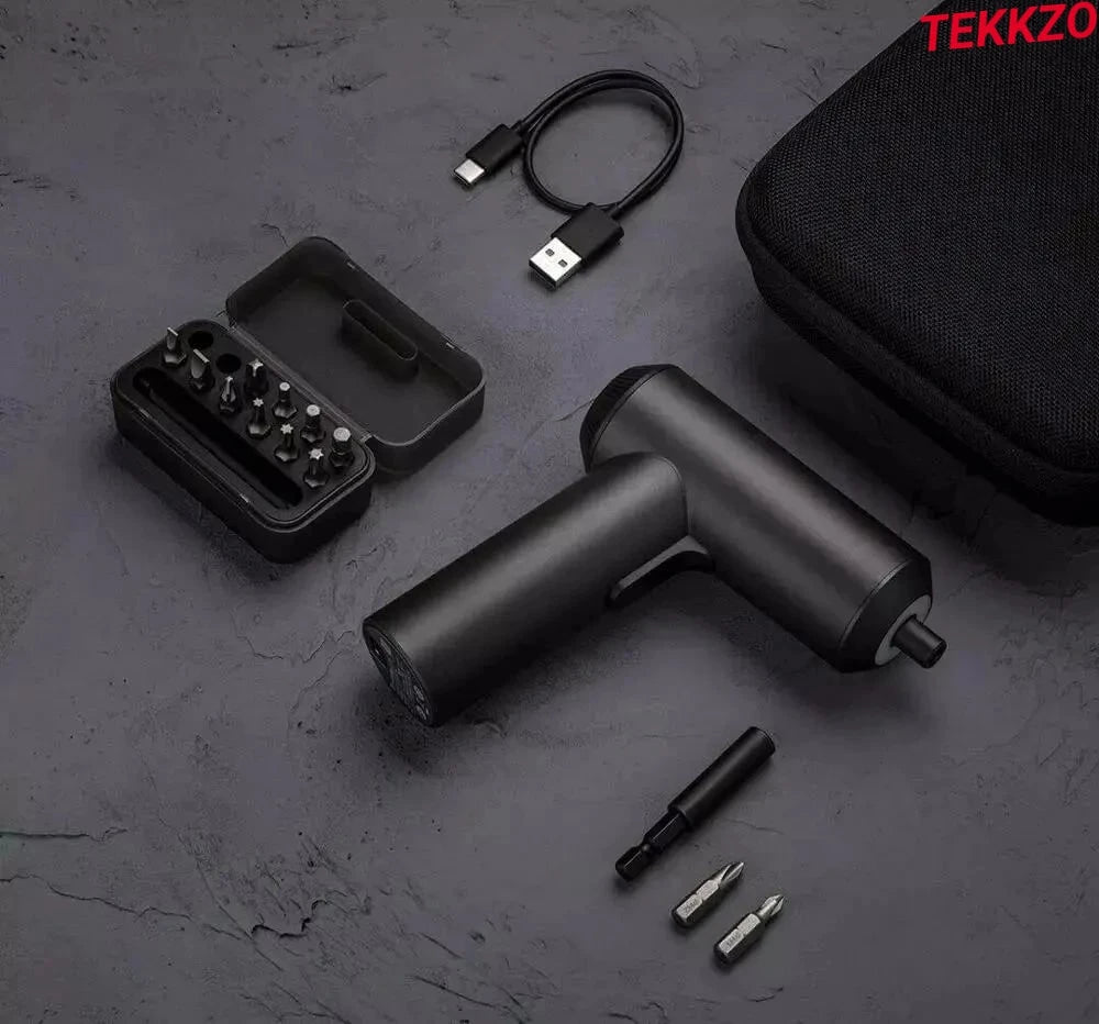 Compact black cordless electric screwdriver with multiple bits, USB charging cable, and carrying case on dark surface